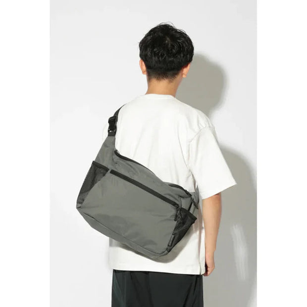 Grey Snow Peak Daily Shoulder Bag worn across a person's back.