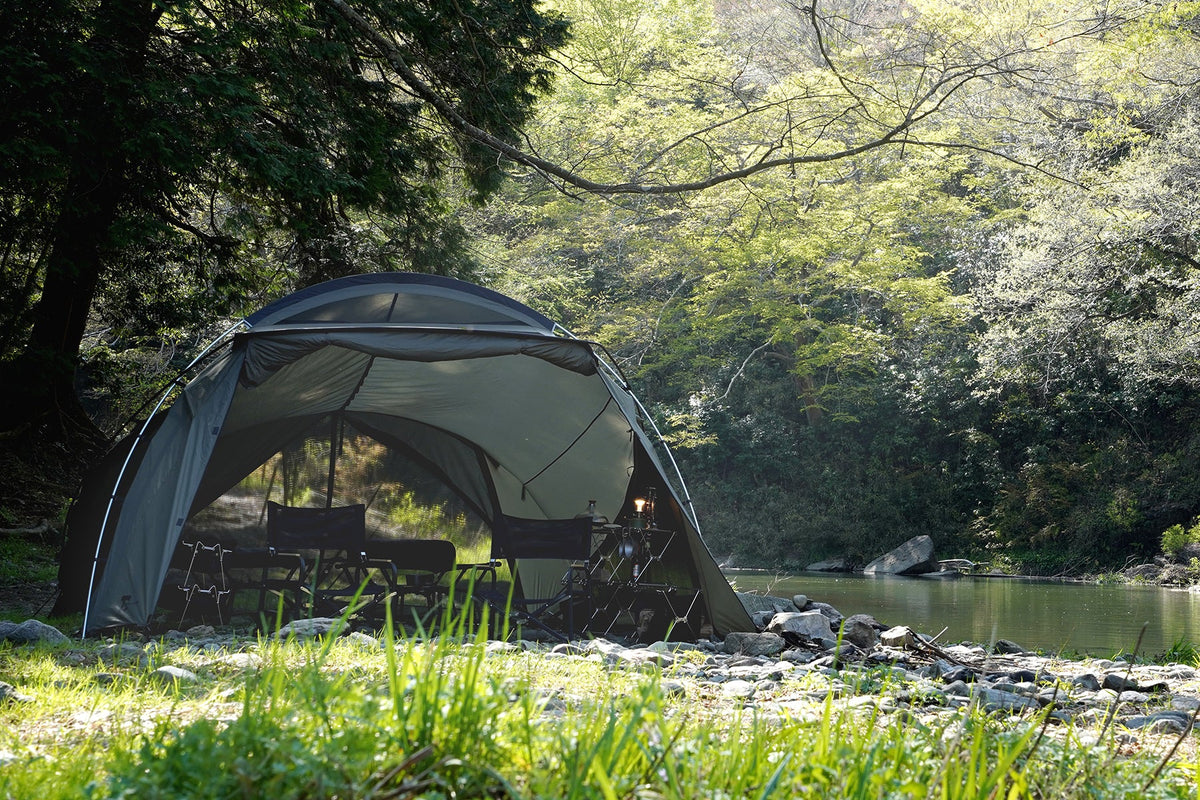 TOKYO CRAFTS Tenbi shelter beside a wooded riverside campsite